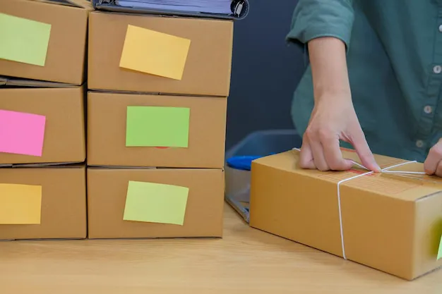 professional mover applying a color-coded asset tag to a moving crate as part of a business relocation checklist in Auckland.