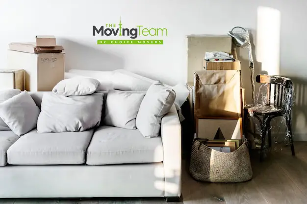 Alt Text: Person planning the budget for furniture moving cost in Auckland by measuring a sofa.