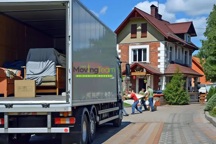 The Moving Team truck parked outside a large brick family home in Botany Downs, East Auckland.