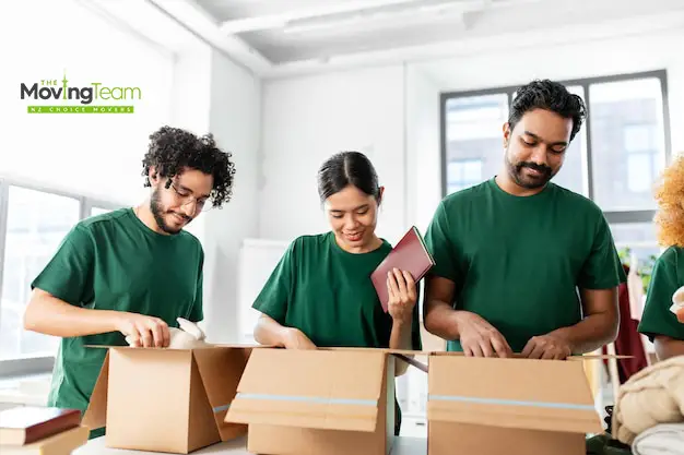 Professional movers placing a protected sofa into a secure furniture storage unit in Auckland.