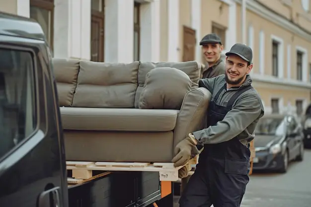 A friendly moving crew loading household boxes and furniture into a truck in Massey.