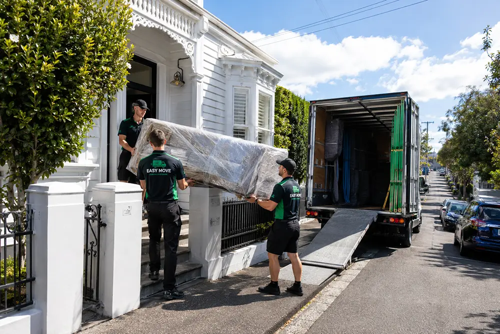Professional Ponsonby movers carefully loading furniture from a heritage wooden villa in Auckland.