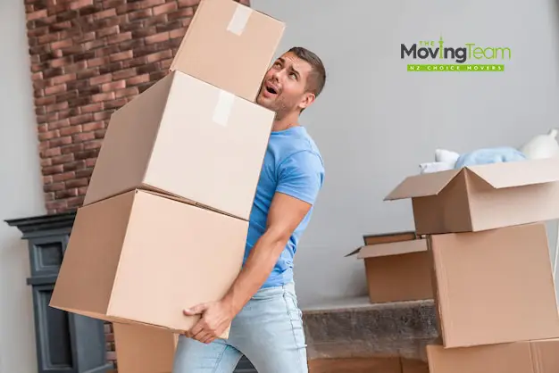 Professional movers safely loading heavy boxes into a rental truck, demonstrating expert moving labor services in Auckland.